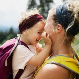 A toddler with her forehead on her moms face