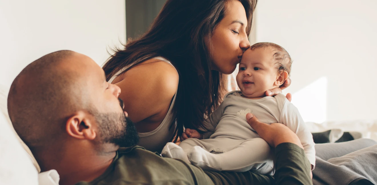 Mom kissing her baby while dad watches
